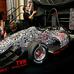students in front of the racing car 